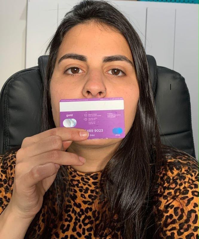 mulher segurando um cartão logo abaixo do nariz, olhando para a frente, como exemplo de foto para medir a DNP