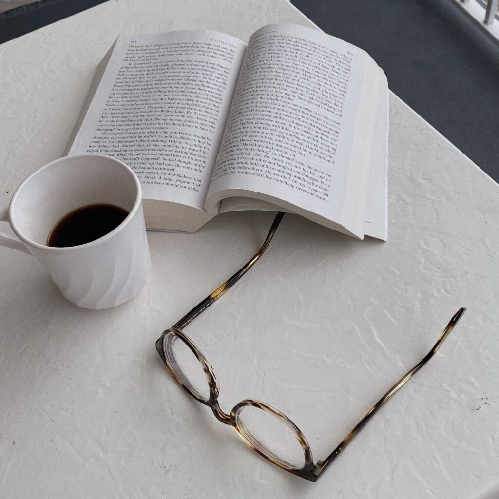 Óculos de grau dobrado sobre as páginas de um livro aberto